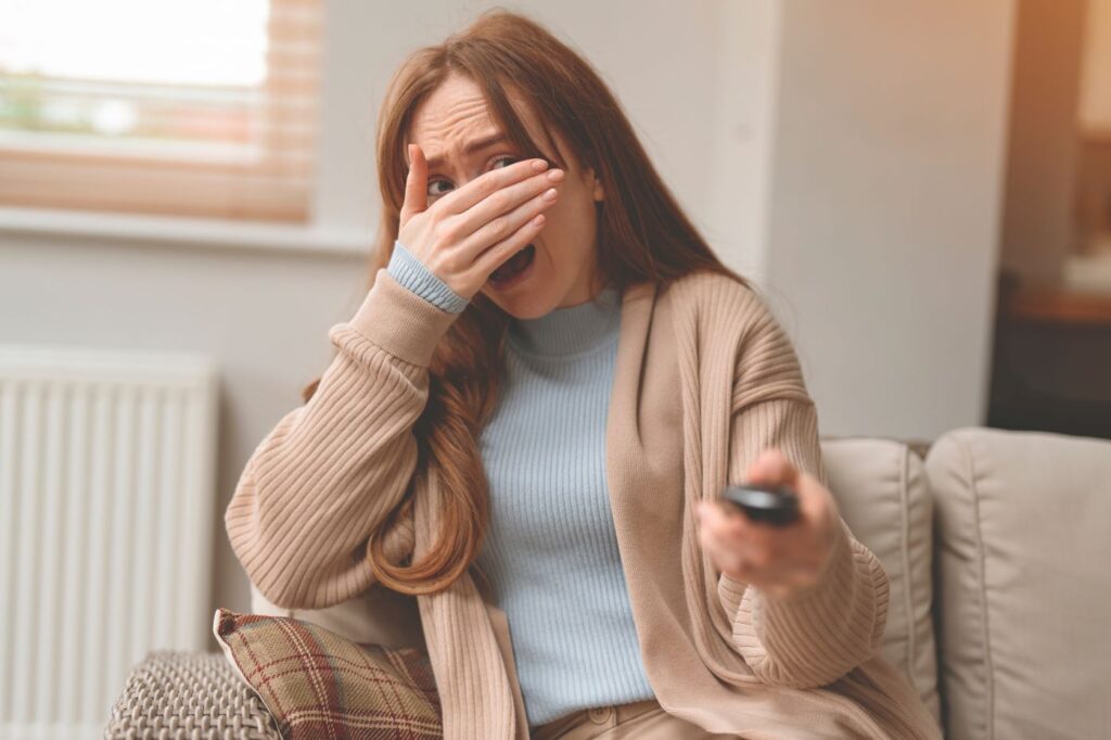 A woman watching a scary movie.